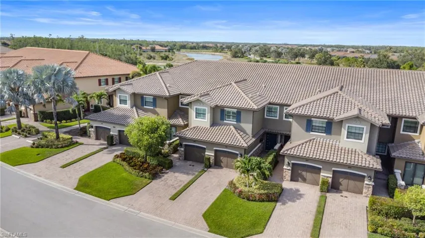 View of front of home featuring stucco siding, a residential view, driveway, a tile roof, and an attached garage