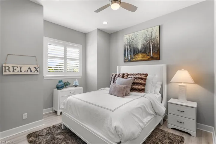 Bedroom with baseboards, light wood-type flooring, a ceiling fan, and recessed lighting