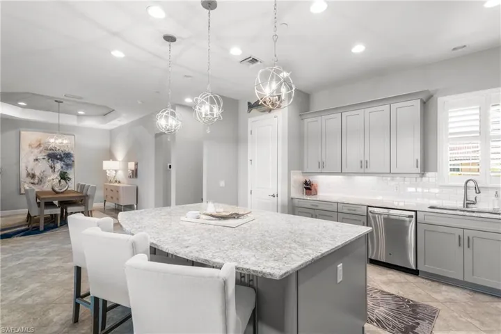 Kitchen with stainless steel dishwasher, a sink, gray cabinetry, recessed lighting, and a center island