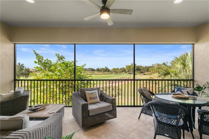 Sunroom featuring ceiling fan, golf course view, and healthy amount of natural light