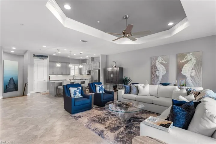 Living area featuring ornamental molding, ceiling fan, recessed lighting, and a tray ceiling