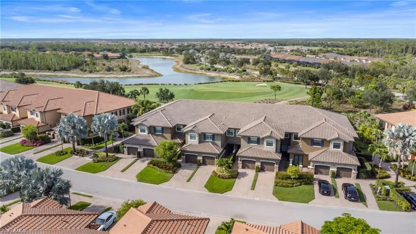 Aerial view of residential area with a golf course and a nearby body of water