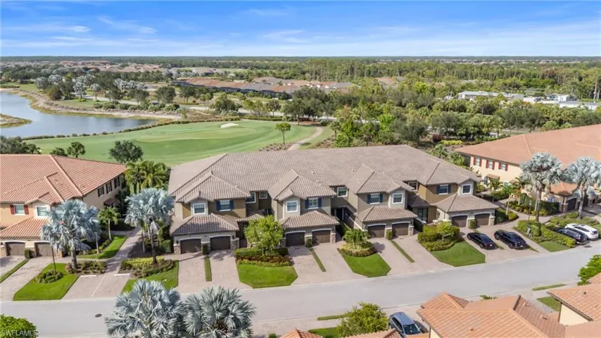 Aerial perspective of suburban area featuring a golf course and a nearby body of water