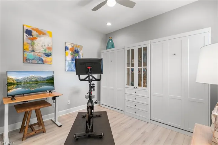 Exercise area featuring a ceiling fan, light wood finished floors, baseboards, and recessed lighting
