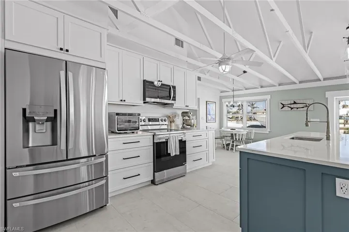Kitchen featuring white cabinetry, sink, ceiling fan, and appliances with stainless steel finishes