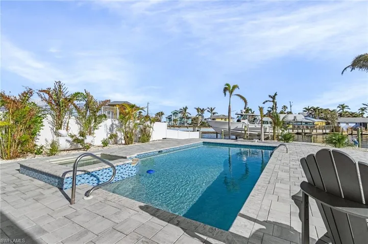 View of pool featuring a patio area, a dock, and a hot tub