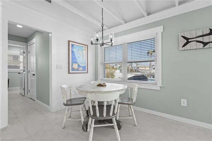 Dining space with a notable chandelier and lofted ceiling with beams