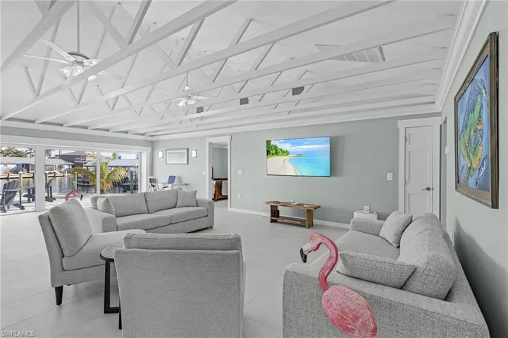 Living room with vaulted ceiling with beams and ceiling fan