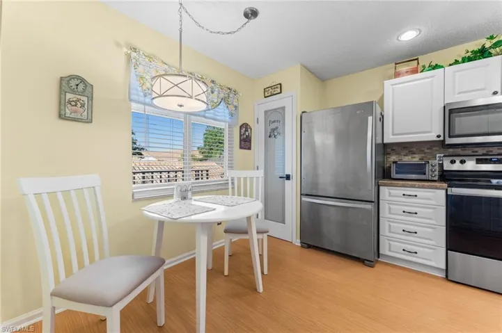 Kitchen featuring white cabinets, light wood-type flooring, appliances with stainless steel finishes, and a toaster