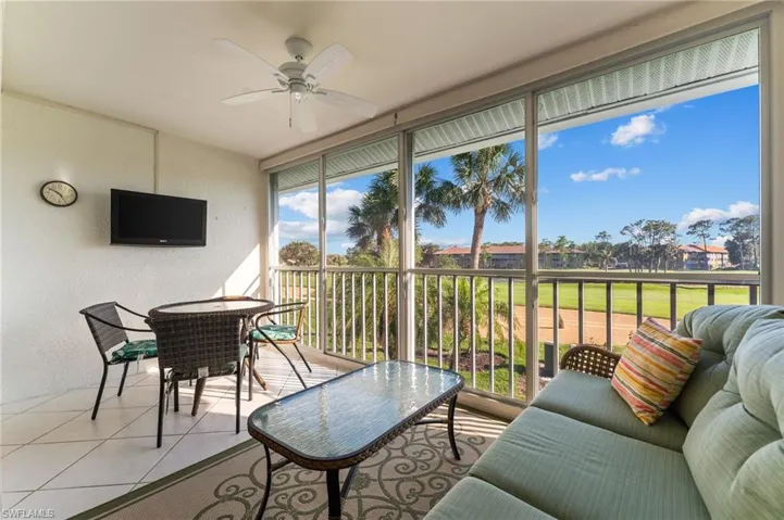 Sunroom featuring tile flooring, a textured wall, a ceiling fan, and outdoor dining space