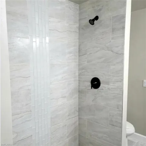 Bathroom with tiled shower and toilet