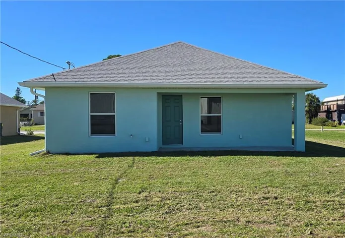 Rear view of house featuring a lawn