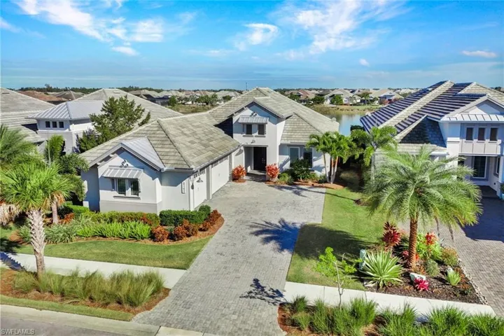 View of front of house with stucco siding, decorative driveway, an attached garage, and a front lawn