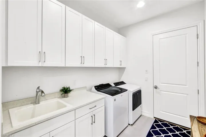 Laundry room with sink, washing machine and dryer, cabinet space, and recessed lighting