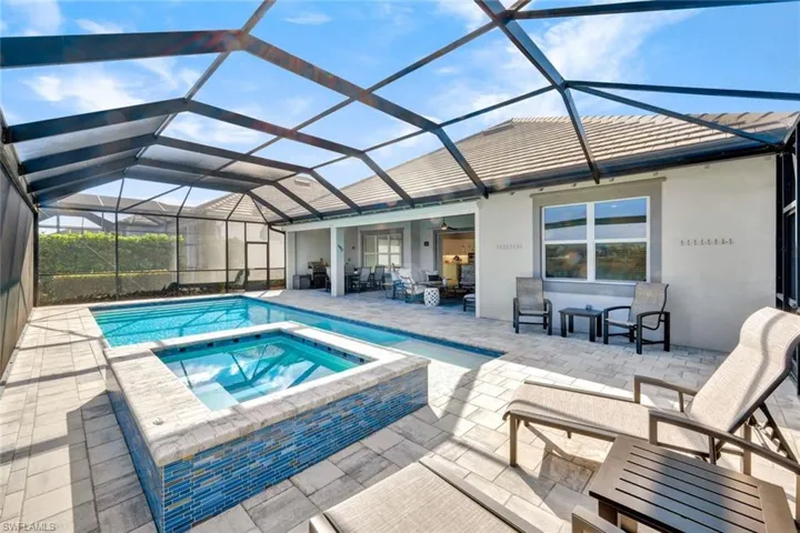 Combined pool / hot tub featuring a sunroom, a patio, and a lanai