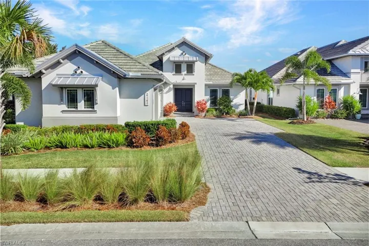 View of front of property featuring stucco siding, decorative driveway, and a front yard