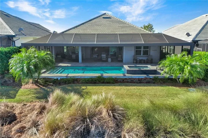Back of property with a patio area, a pool with connected hot tub, stucco siding, and a sunroom