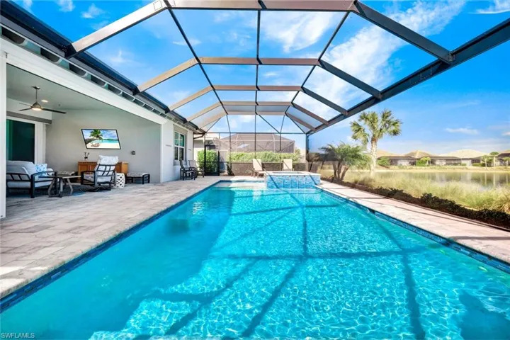 Relaxing pool / spa with a patio area, a lanai, a sunroom, and a residential view