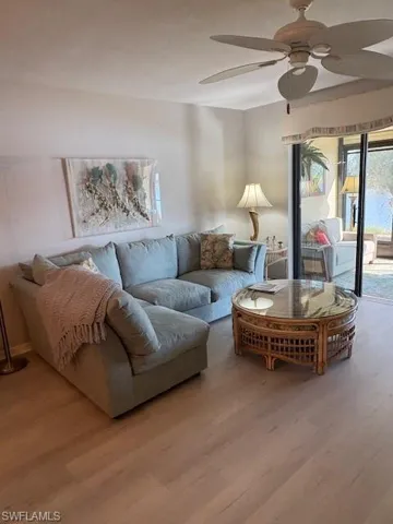 Living room with ceiling fan and wood finished floors