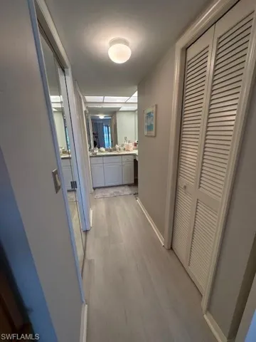 Corridor featuring light wood-style floors and baseboards