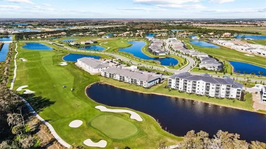 Drone / aerial view of a golf course and a nearby body of water