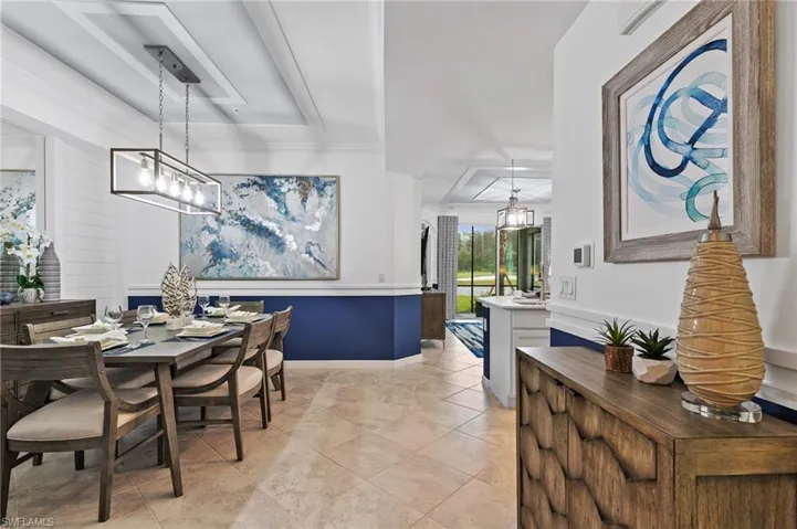 Dining room with a raised ceiling and light tile patterned flooring