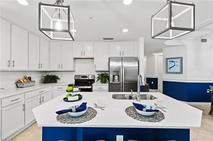 Kitchen featuring stainless steel appliances, recessed lighting, a kitchen island with sink, and white cabinets