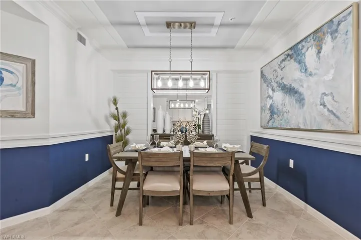 Dining room featuring a raised ceiling and tile patterned floors