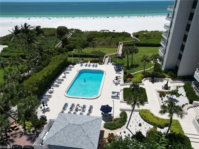 Birds eye view of property featuring a water view and a beach view