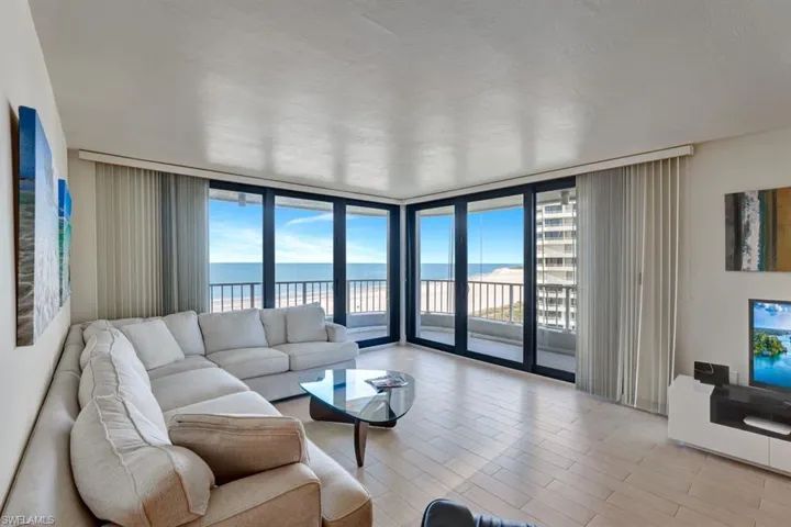 Living room with floor to ceiling windows, light hardwood / wood-style flooring, and a water view