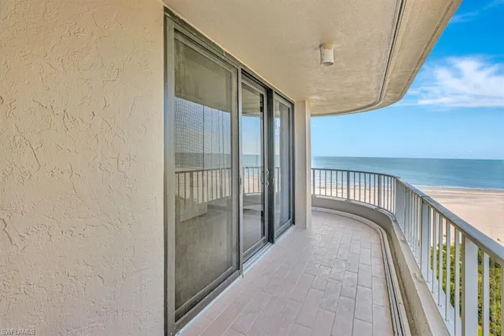 Balcony featuring a water view and a view of the beach