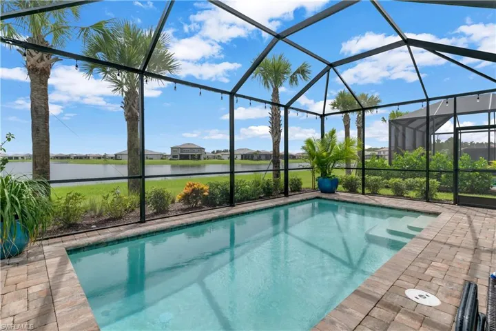 View of swimming pool featuring a lanai, a patio area, and a water view