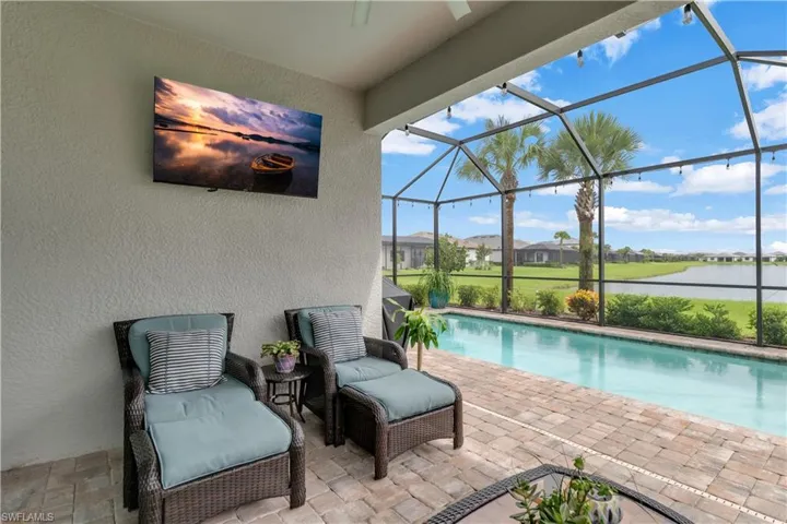 View of pool with glass enclosure and a patio