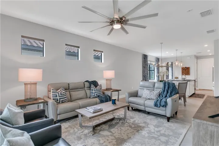 Living room with ceiling fan with notable chandelier