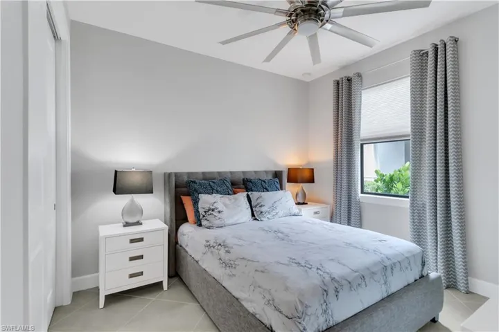 Bedroom with ceiling fan and light tile patterned flooring