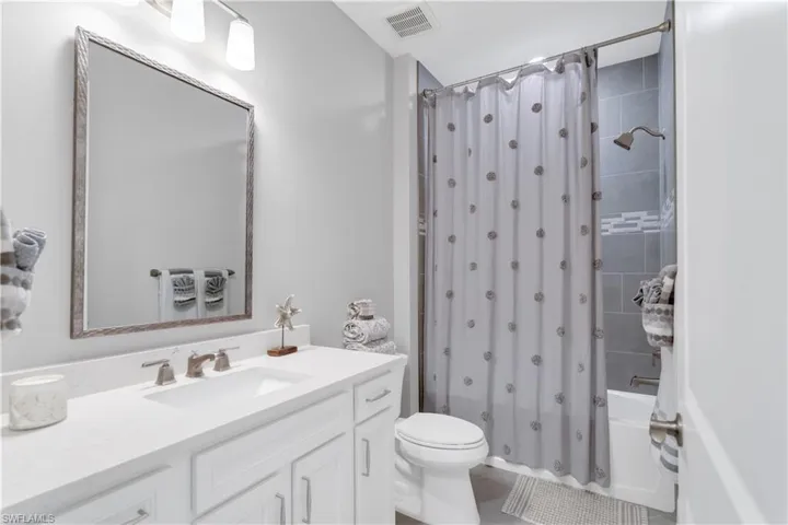 Full bathroom featuring tile patterned flooring, vanity, toilet, and shower / tub combo