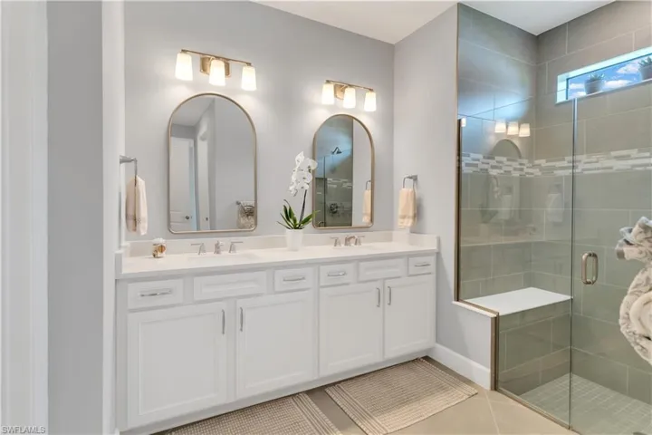 Bathroom with tile patterned flooring, vanity, and an enclosed shower