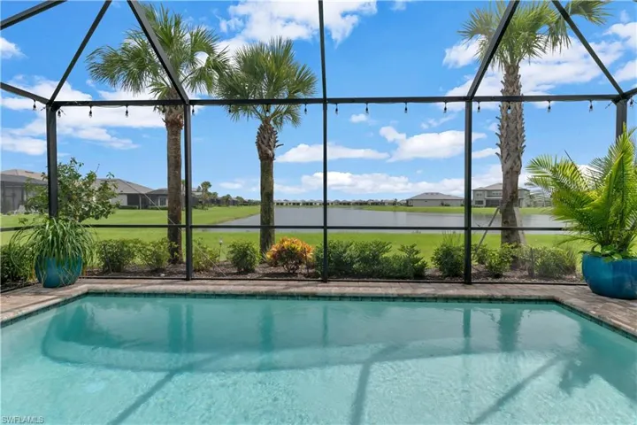 View of swimming pool with glass enclosure and a water view