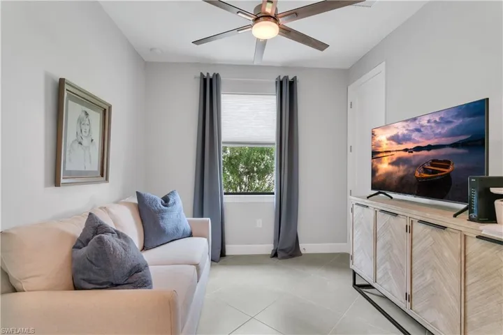 Living room featuring ceiling fan and light tile patterned floors
