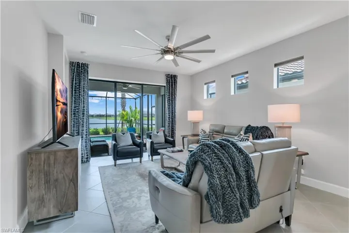 Tiled living room featuring a healthy amount of sunlight and ceiling fan