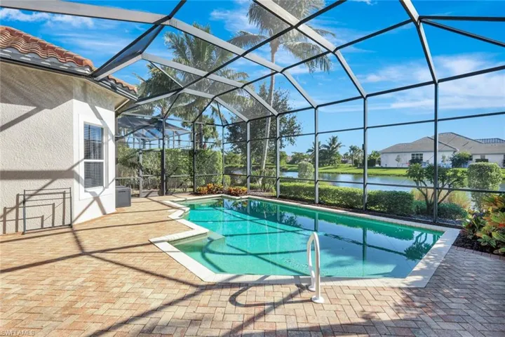 Swimming pool with a water view, a sunroom, a patio, and a lanai