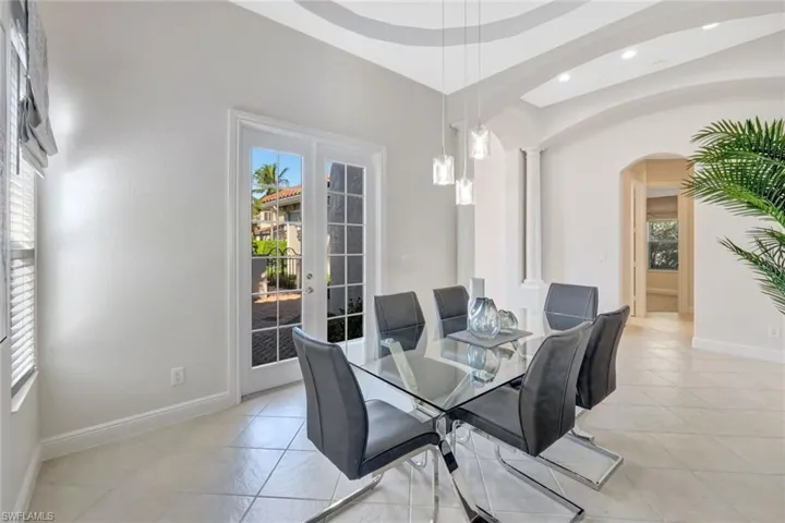 Dining space featuring healthy amount of natural light, arched walkways, and french doors