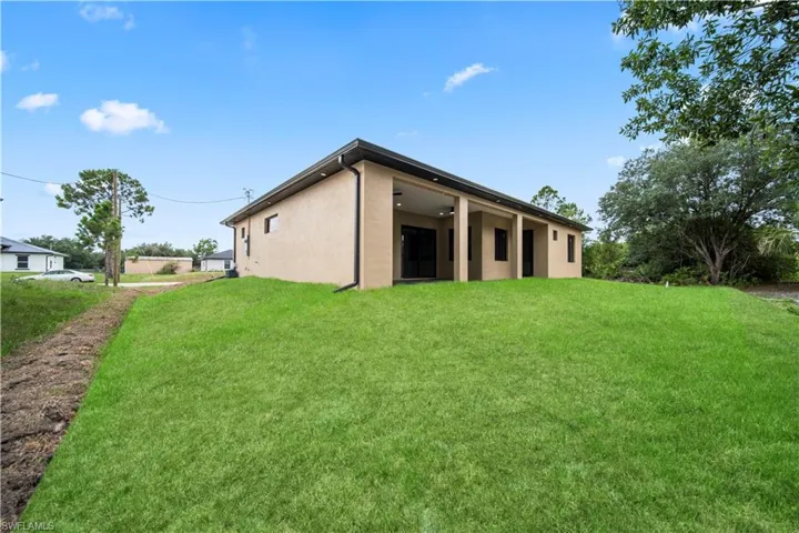 Expansive green lawn with a stucco exterior