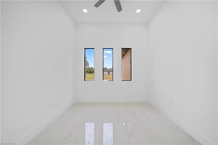 High ceilings with recessed lighting and a ceiling fan