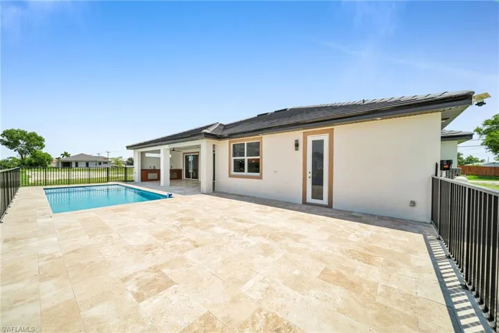 Back of property with fence, a ceiling fan, a fenced in pool, stucco siding, and a patio area
