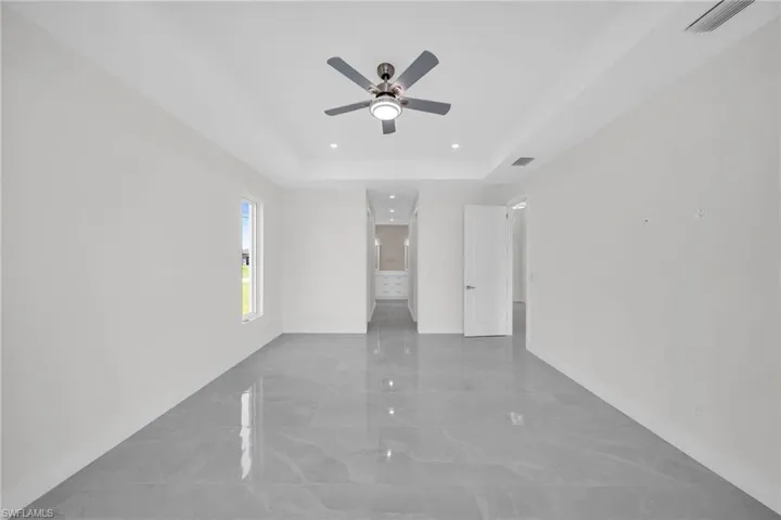 Unfurnished room with marble finish floor, a raised ceiling, visible vents, and baseboards