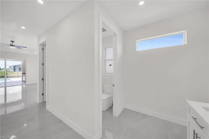 Bathroom featuring marble finish floor, baseboards, a wealth of natural light, and recessed lighting