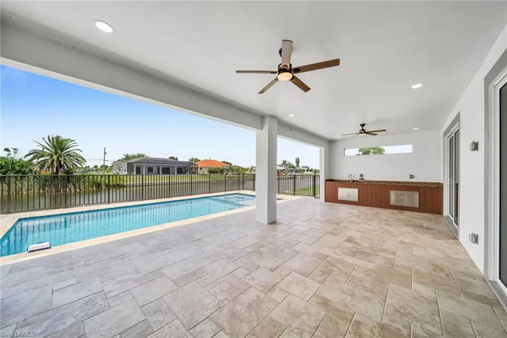 View of swimming pool with a patio, a pool with connected hot tub, a fenced backyard, and a ceiling fan