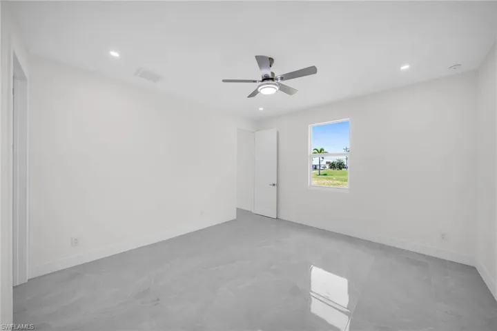 Unfurnished room with a ceiling fan, recessed lighting, visible vents, and baseboards