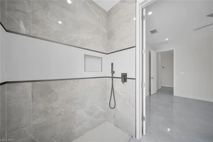 Bathroom featuring baseboards, visible vents, and a tile shower